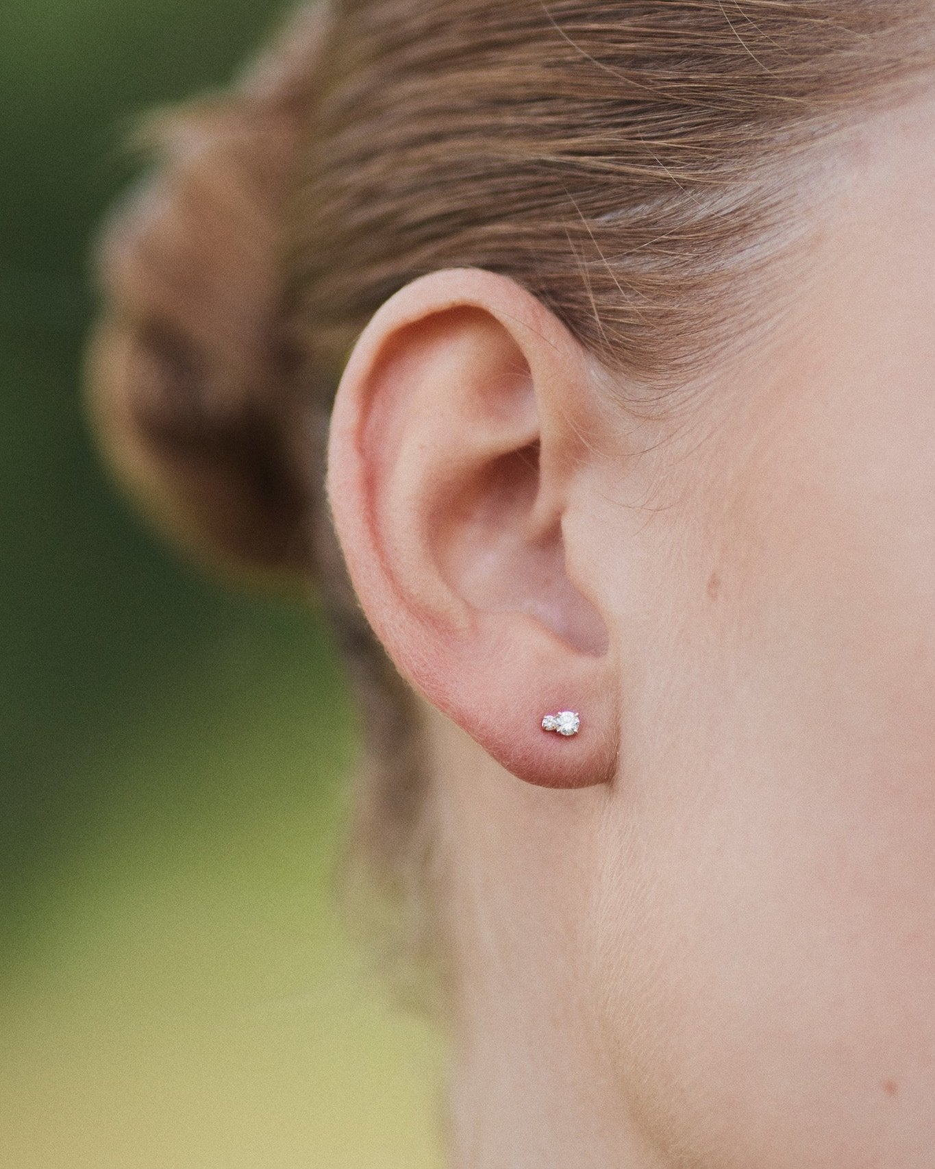 Diamond Duo Stud earring in 14K recycled gold with two lab-grown diamonds, worn on the ear lobe.