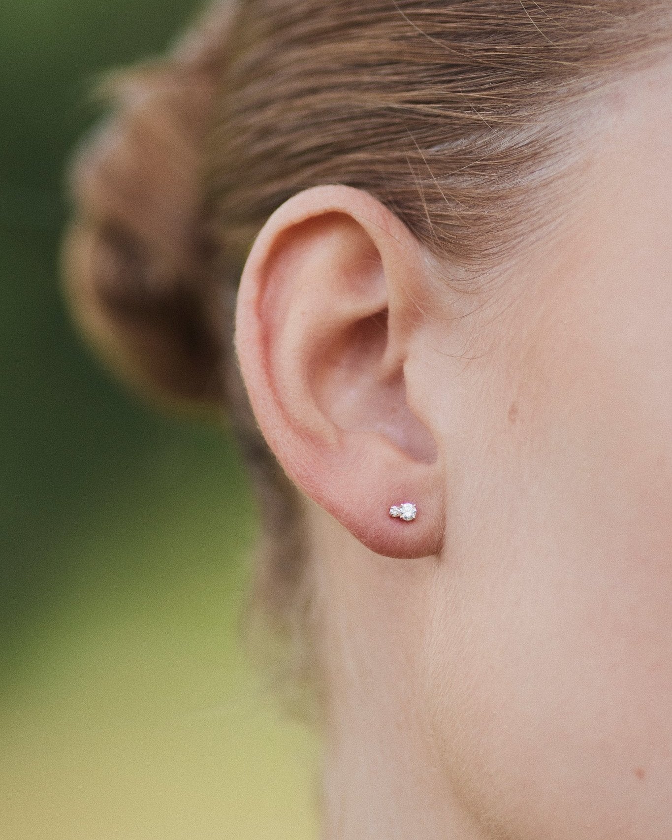 Diamond Duo Stud earring in 14K recycled white gold with two lab-grown diamonds, worn on the ear lobe.