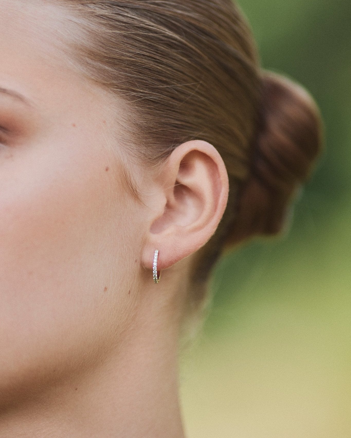Medium Diamond Hoop gold earring worn on ear lobe.