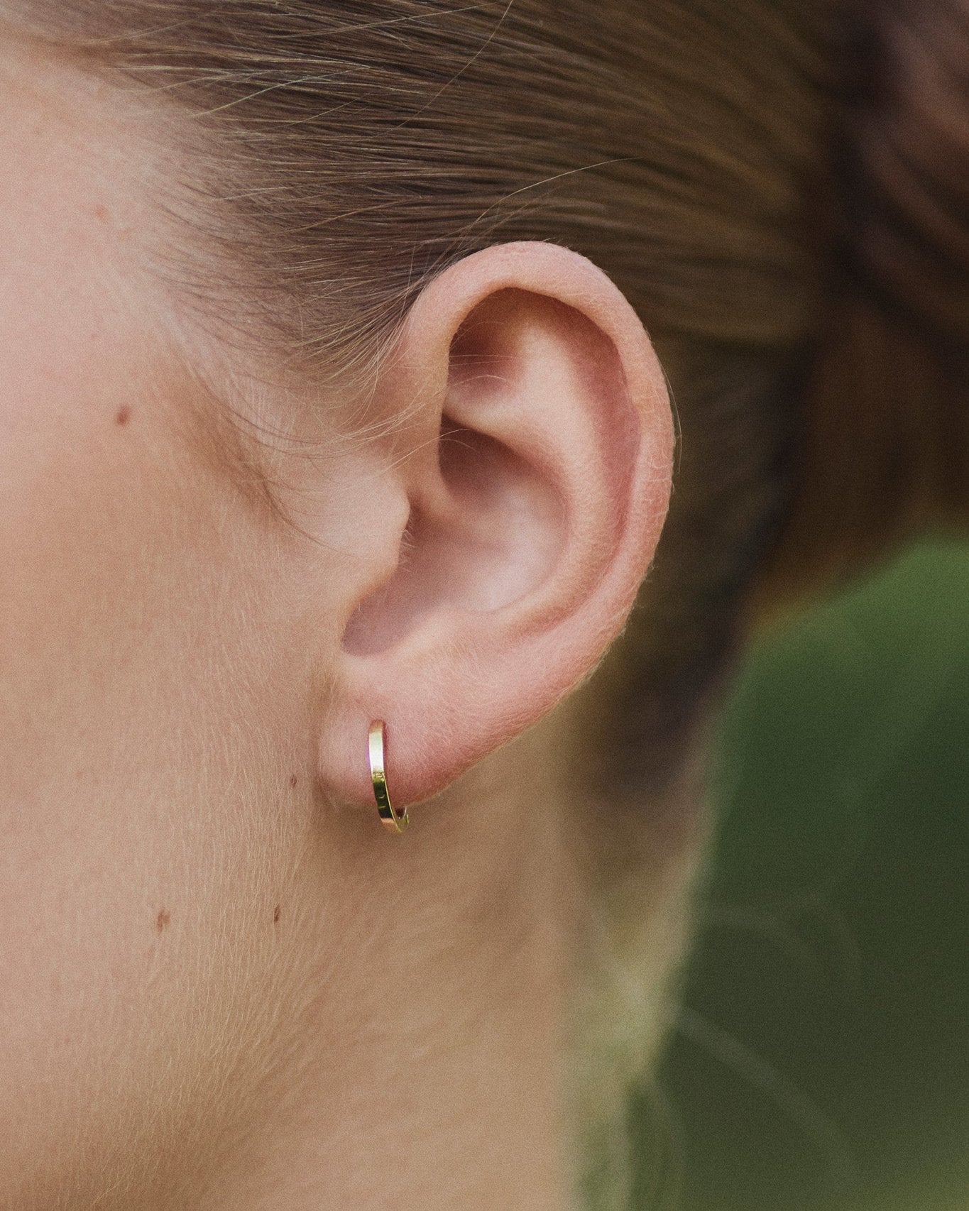 Close-up of ear with Small Hoop earring in 14K gold.