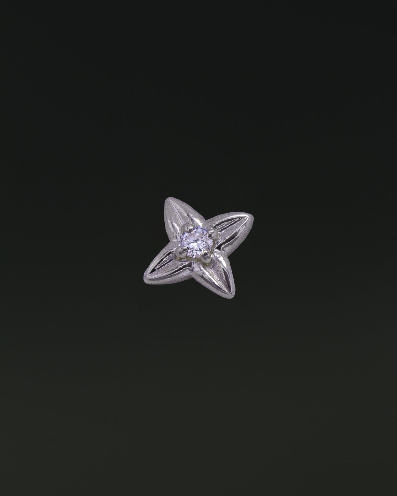 A single white gold stud earring shaped like a four-petal flower, with a small diamond in the center.