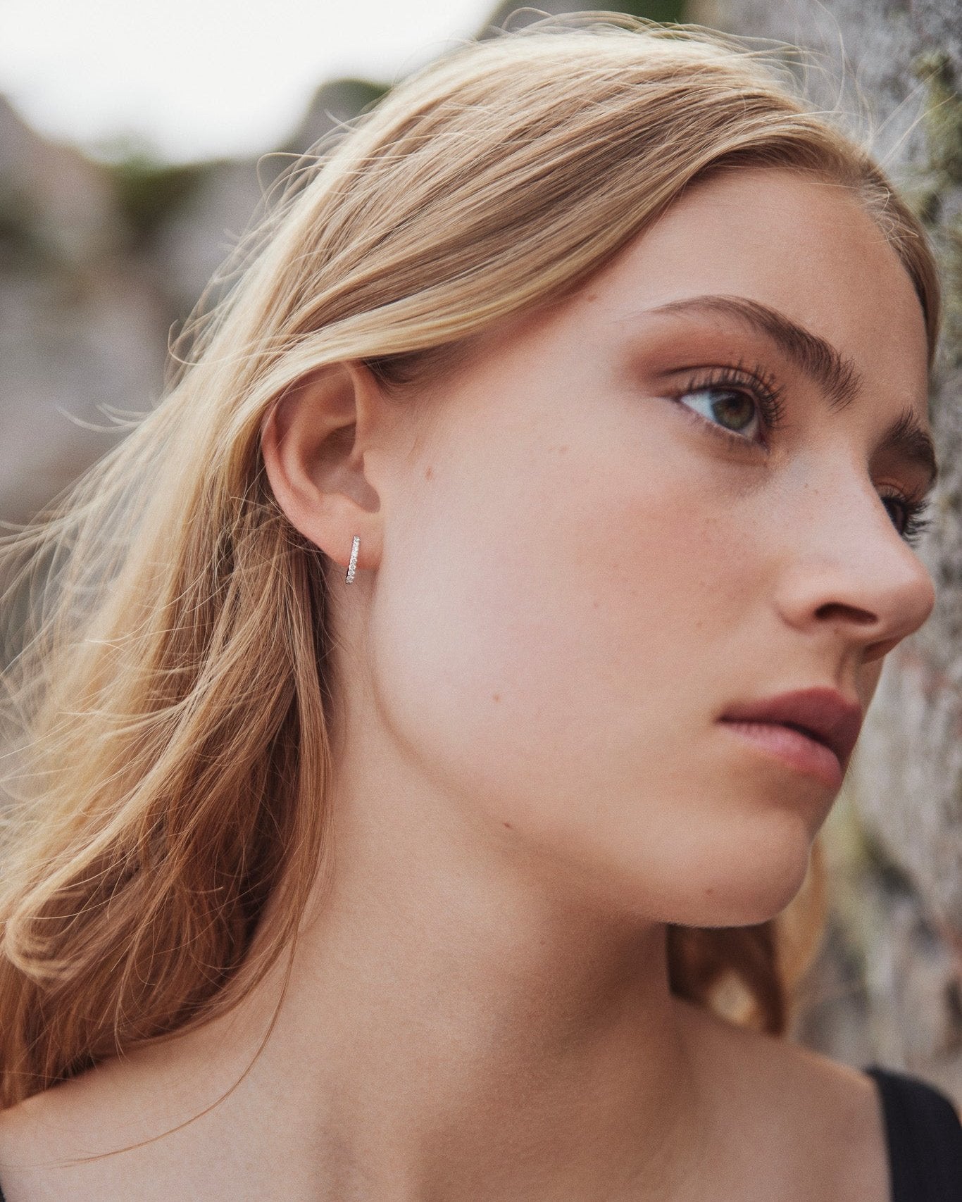 Model wearing the Small Diamond Hoop earring in recycled 14K white gold, set with 9 lab-grown diamonds in a click-closure design.